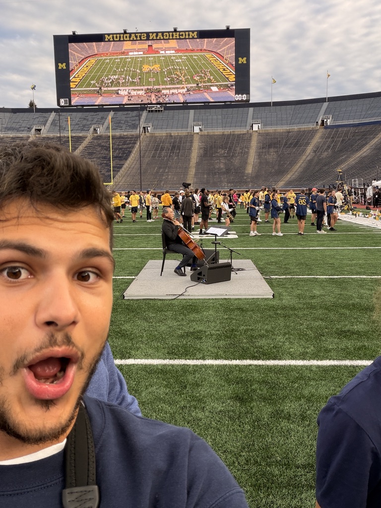 Yo-Yo Ma performing on the field at Michigan Stadium with the band