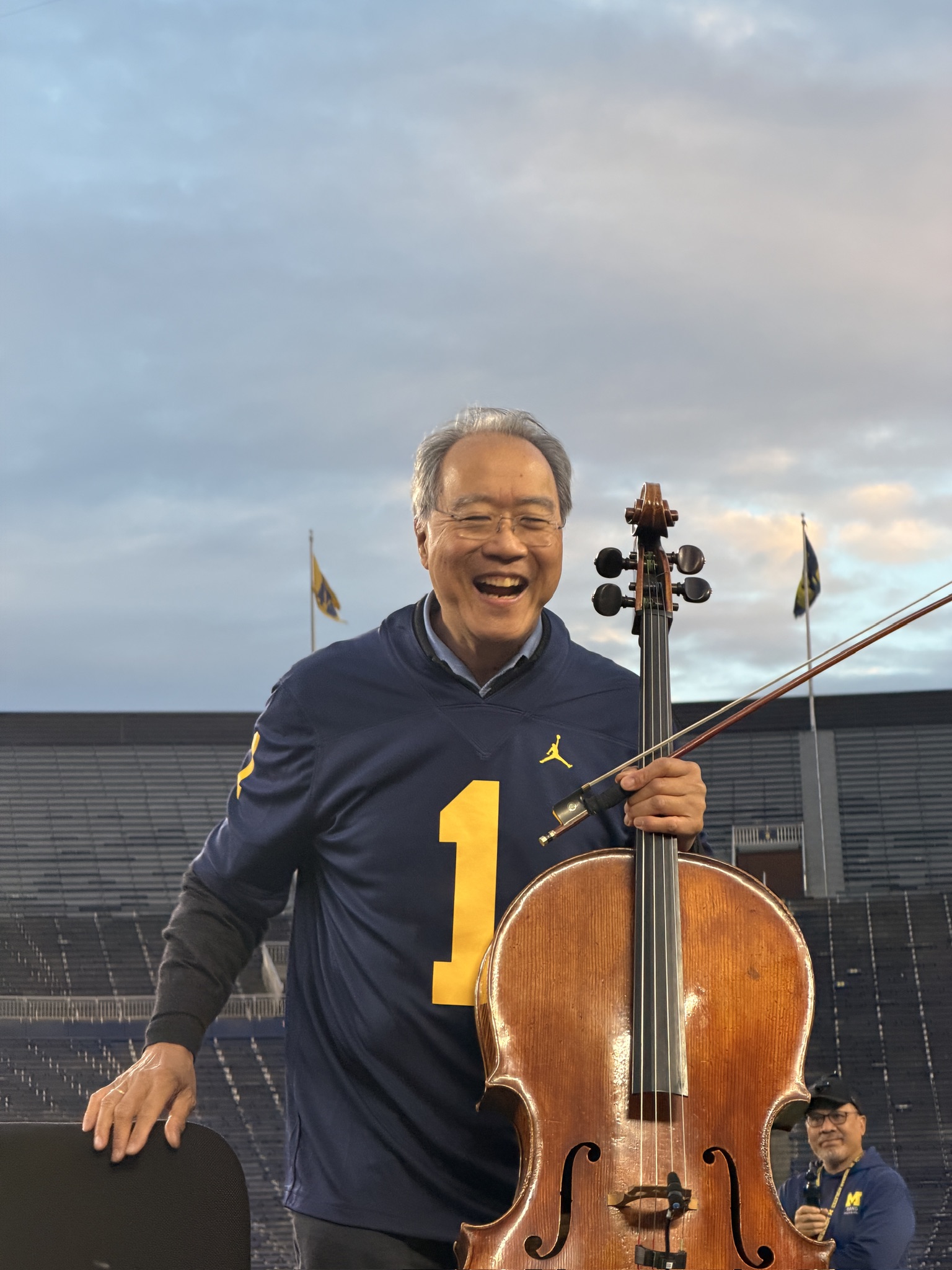 Yo-Yo Ma with his cello in a Michigan jersey at the Big House
